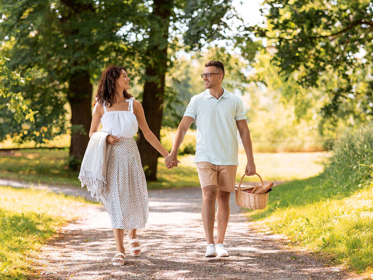Glückliches Paar spaziert im Sommer gemeinsam durch die Natur im Emsland und genießt die Zweisamkeit