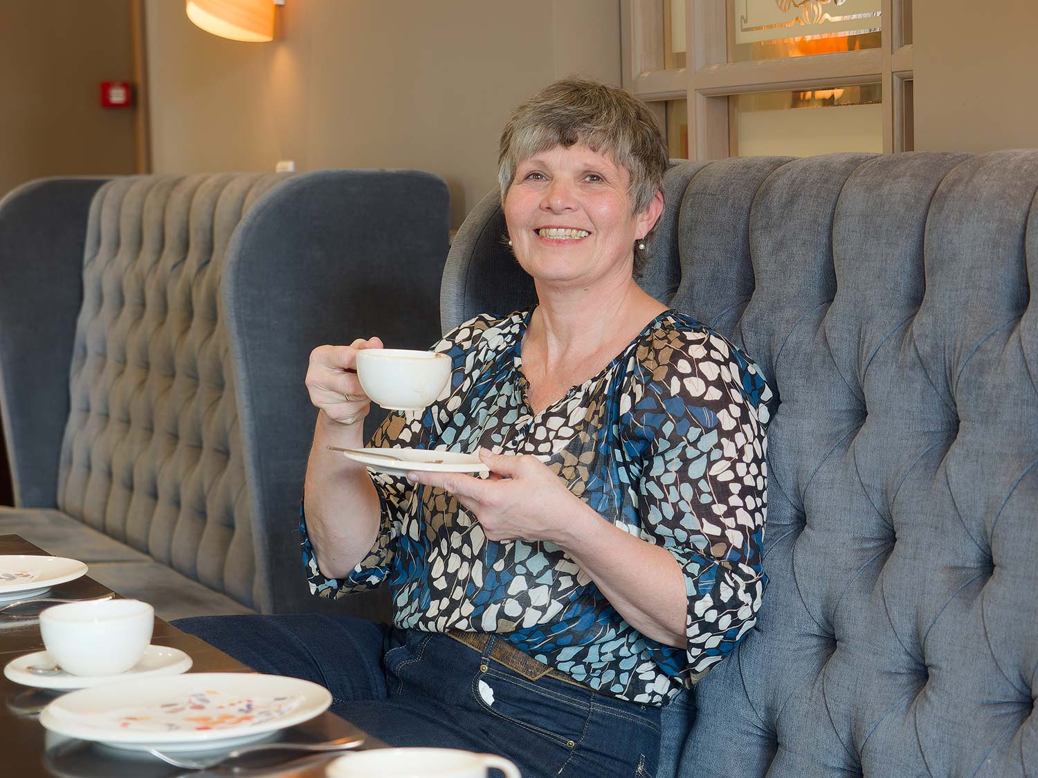 Frau genießt eine Tasse Tee im gemütlichen Frühstücksraum des Hotel von Euch im Emsland